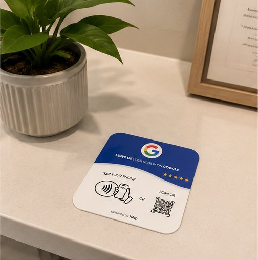XTap review card on a reception counter near a plant
